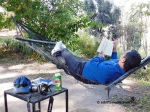 Relaxing in a hammock reading a book at Park Woods Shoghi.